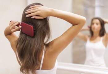 pente ou escova / mulher na frente do espelho escovando o cabelo